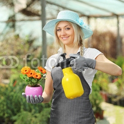 A_beautiful_female_gardener_watering_a_plant.jpg