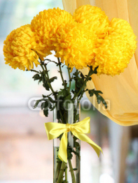 bright_yellow_chrysanthemums_in_glass_vase_on_wooden_table.jpg